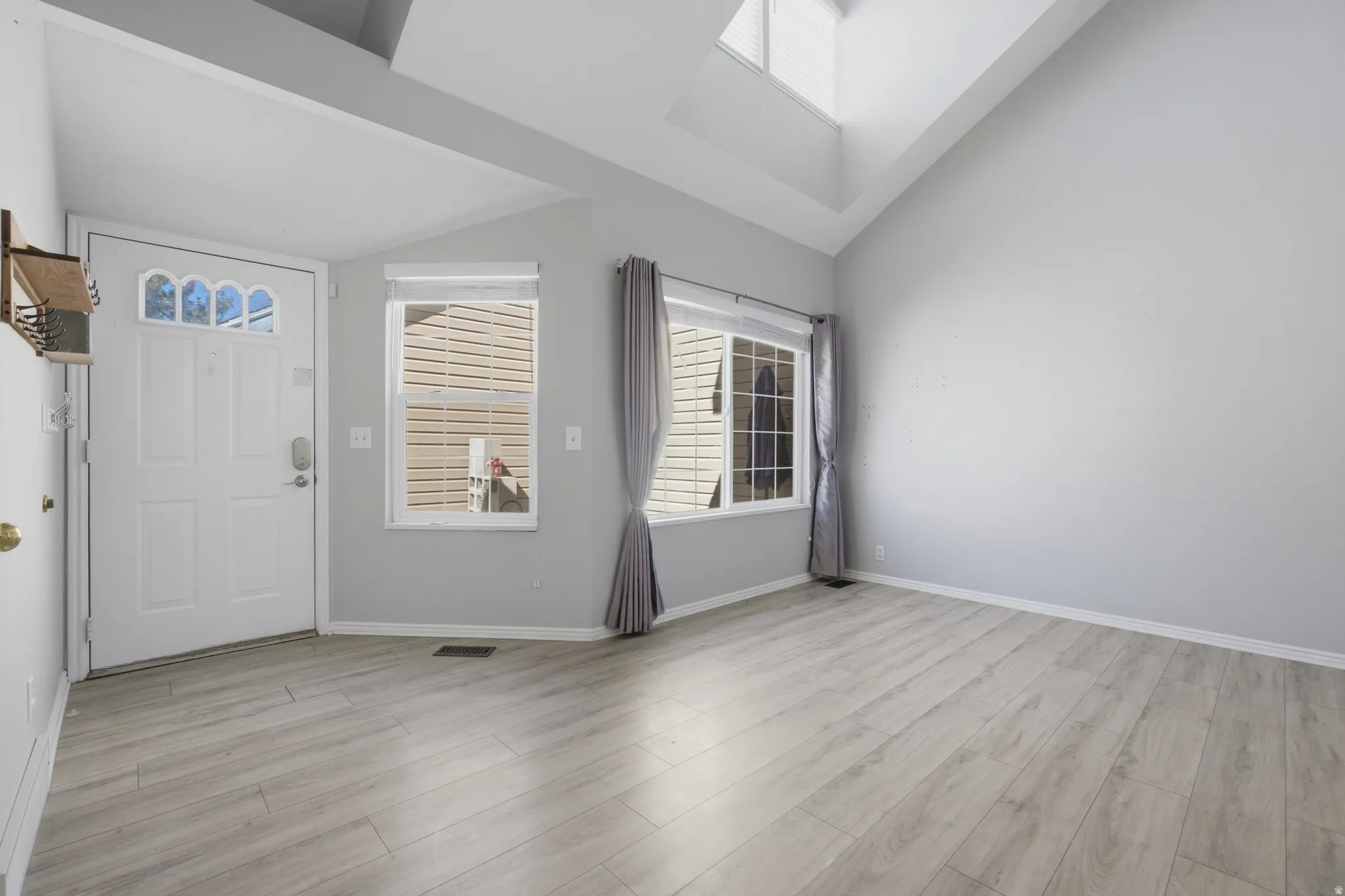 Entrance foyer featuring light wood-style floors and lofted ceiling