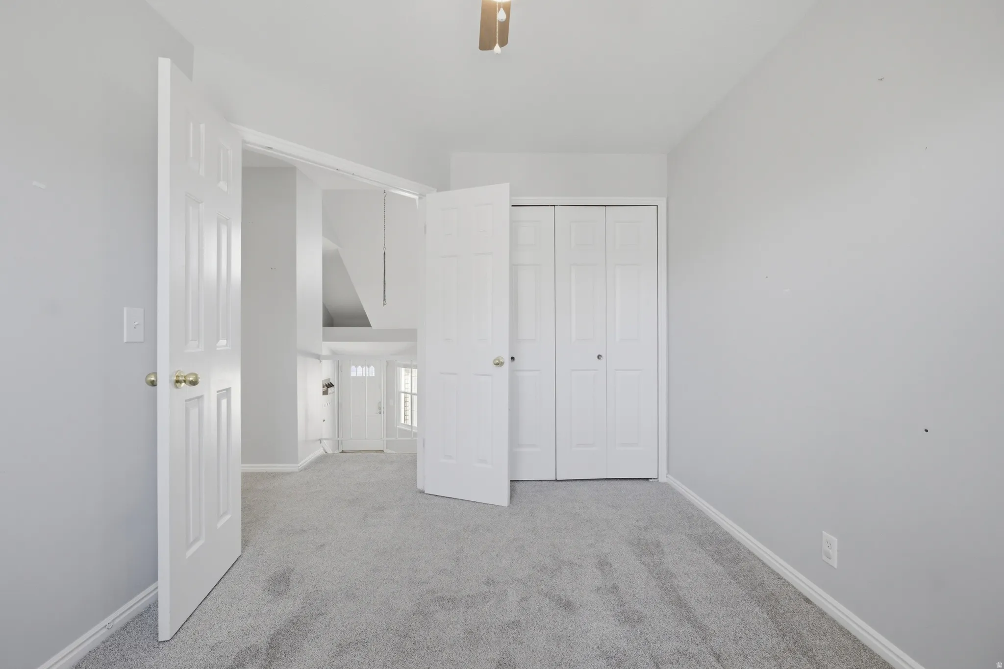 Unfurnished bedroom with light carpet, a closet, and ceiling fan
