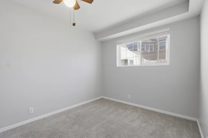 Spare room with light carpet and a ceiling fan