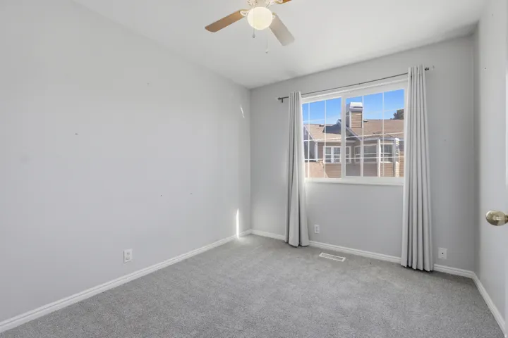 Unfurnished room featuring light colored carpet and a ceiling fan