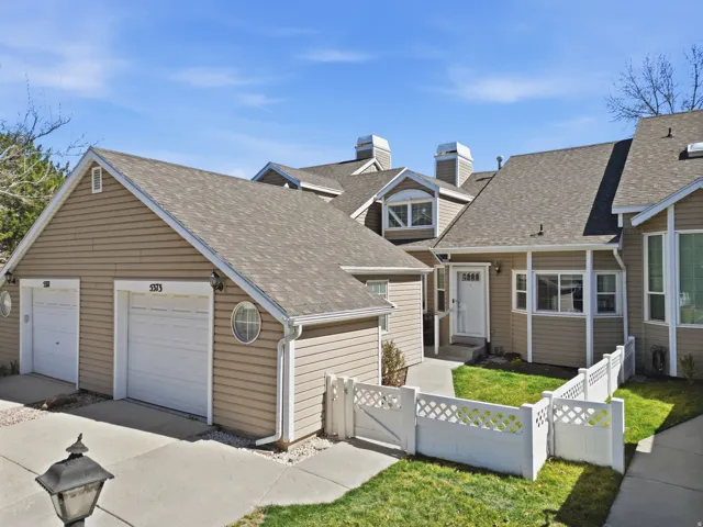 View of front of home with a chimney, a fenced front yard, a shingled roof, and a gate