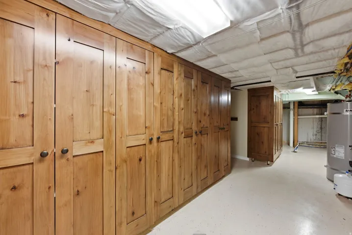 Custom wood-finish cabinetry with dark hardware and a light-toned flooring