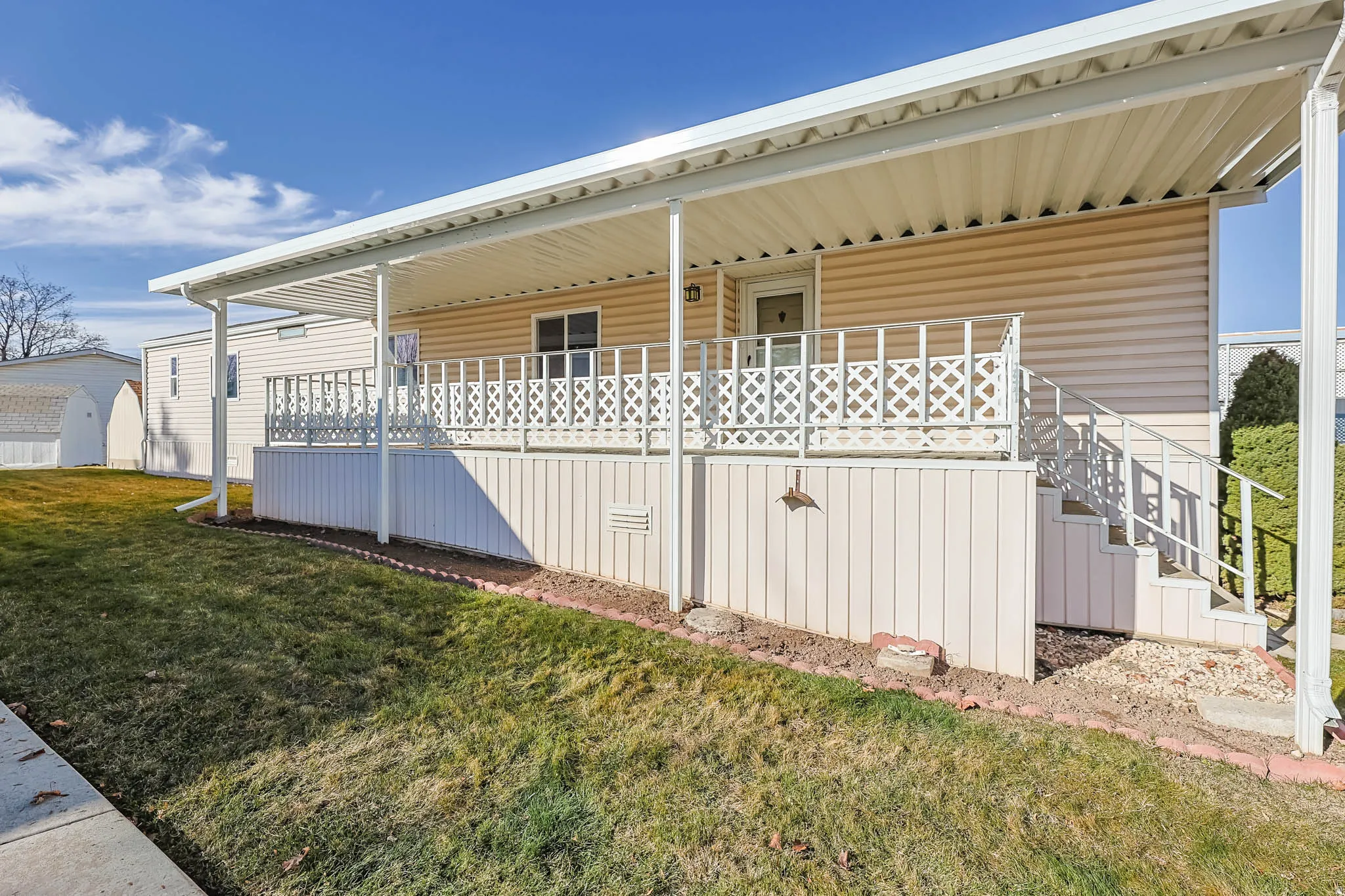 View of property exterior featuring a yard, stairway, and covered porch