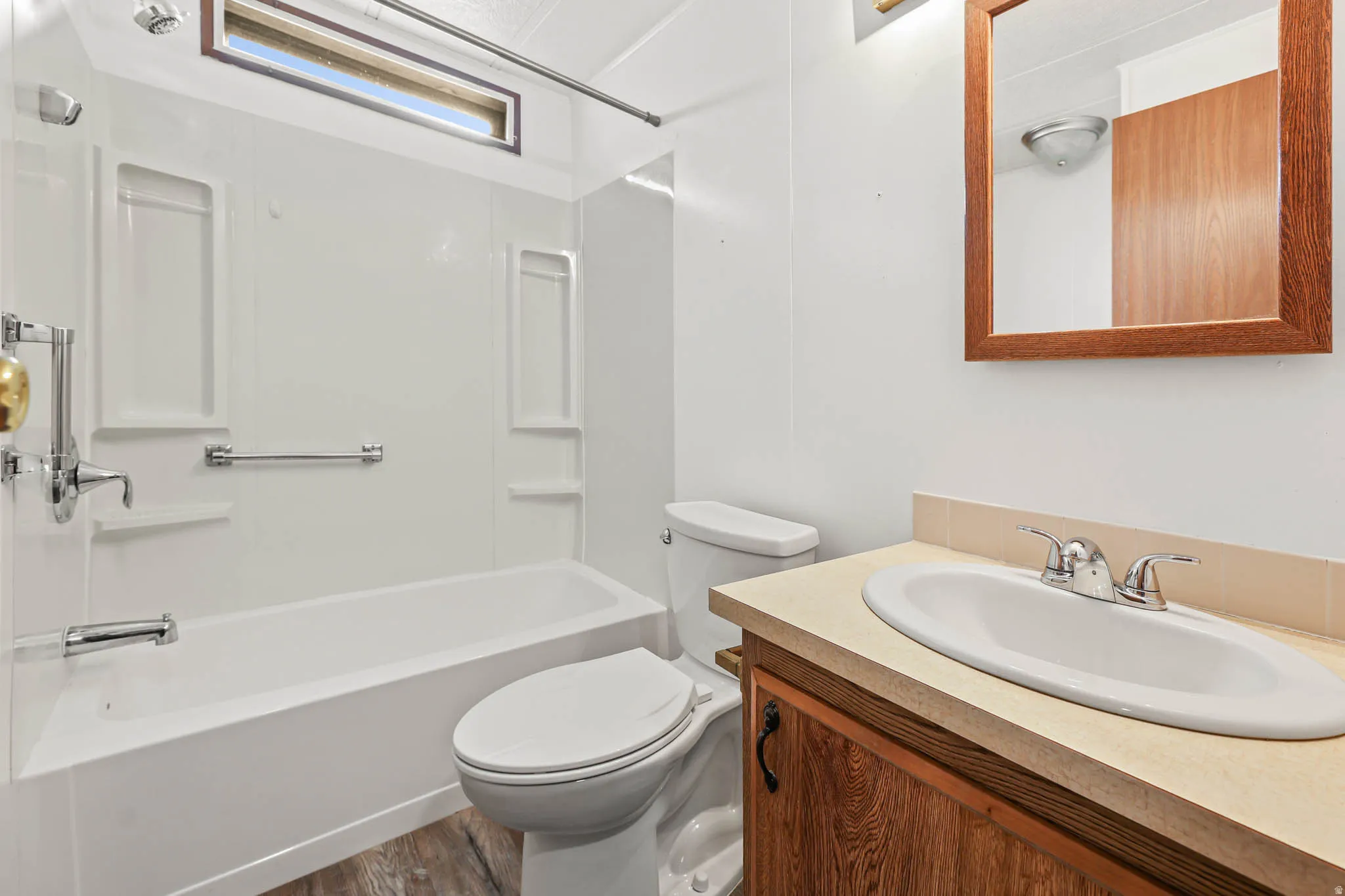 Bathroom featuring vanity, bathing tub / shower combination, and dark wood finished floors
