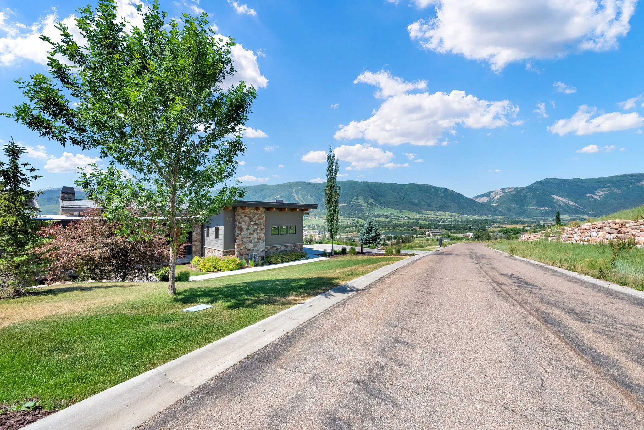 View of asphalt road with curbs and a mountain view