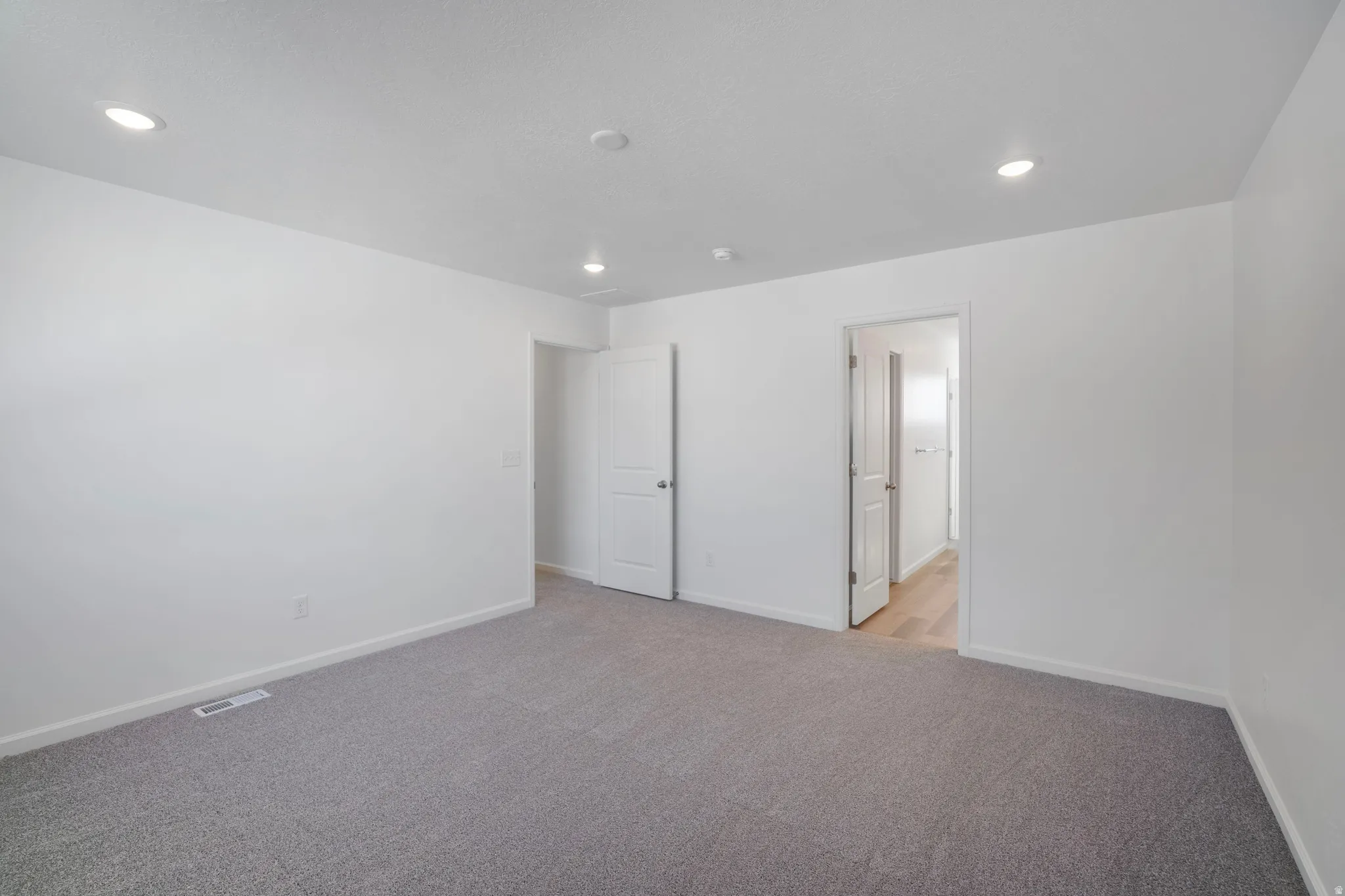 Unfurnished bedroom featuring light carpet and recessed lighting