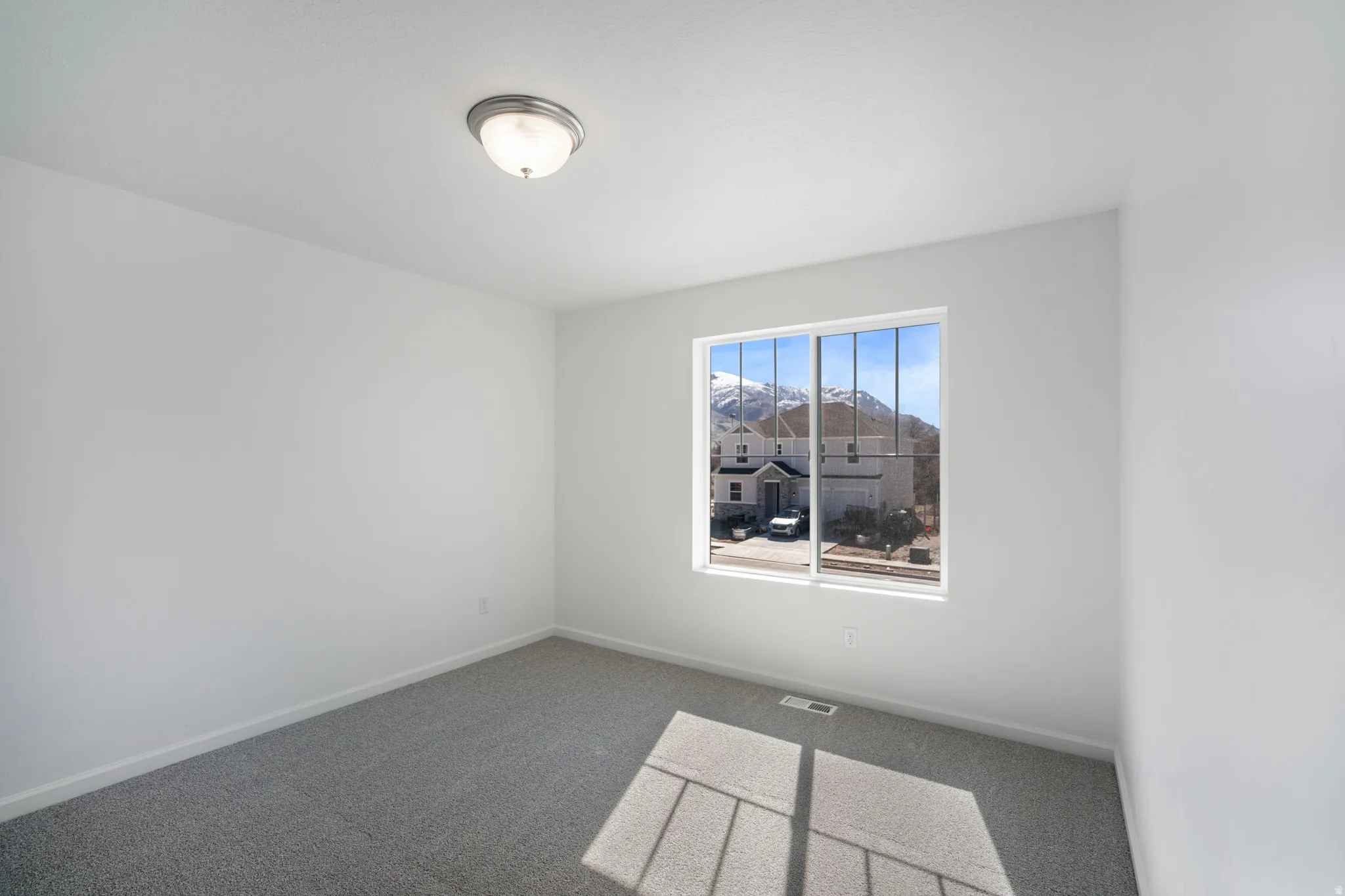 Spare room with baseboards and dark colored carpet