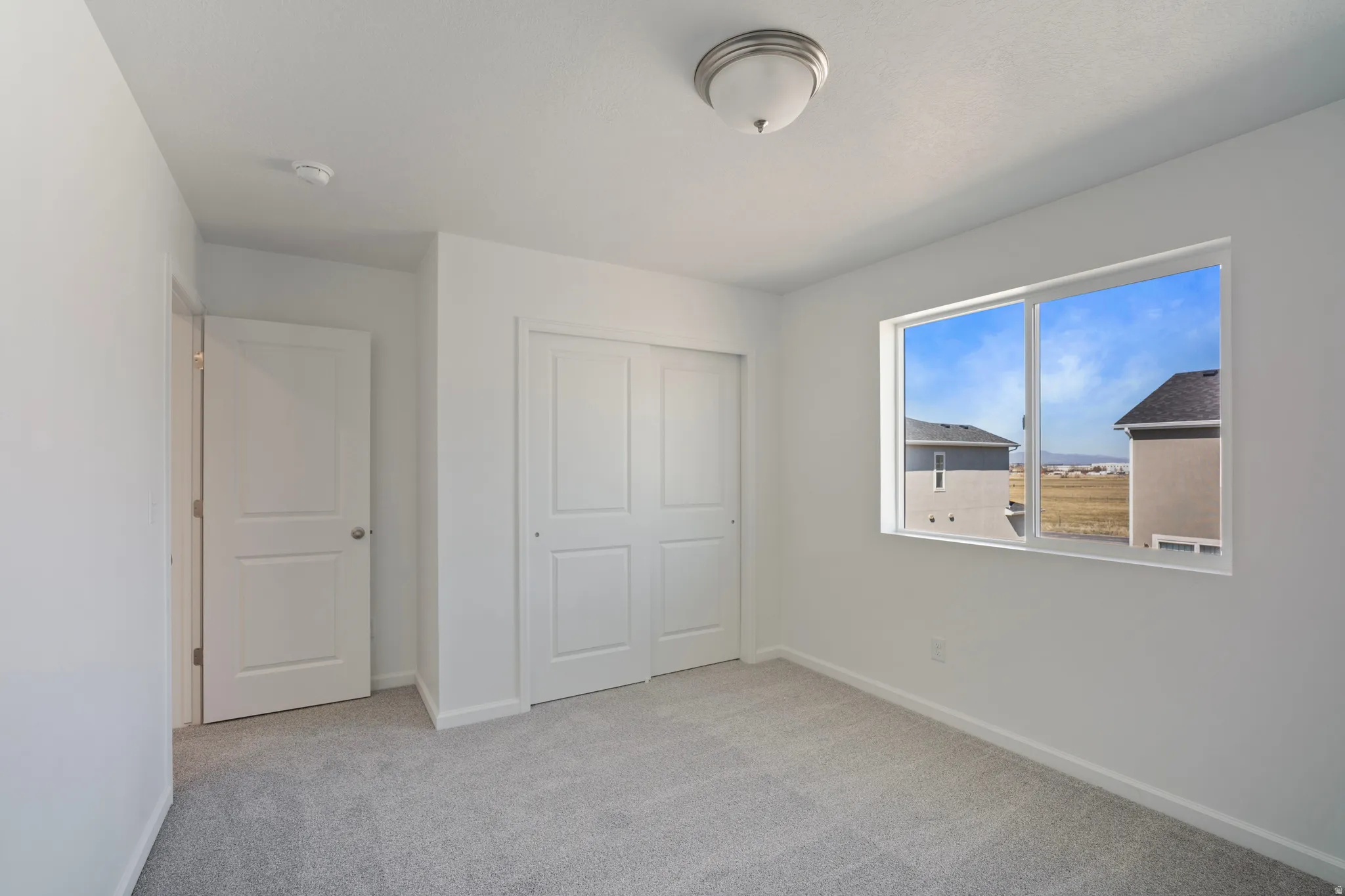 Unfurnished bedroom featuring light colored carpet and a closet
