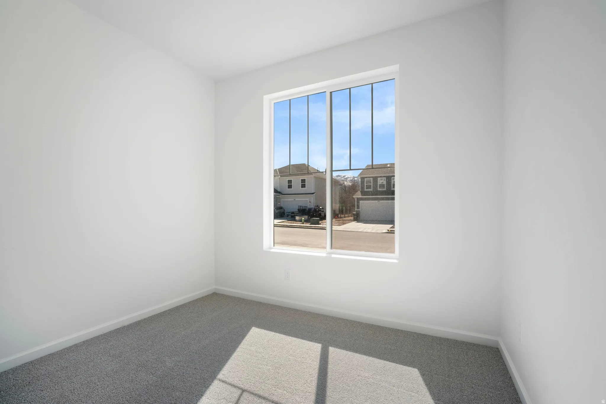 Empty room featuring carpet and baseboards