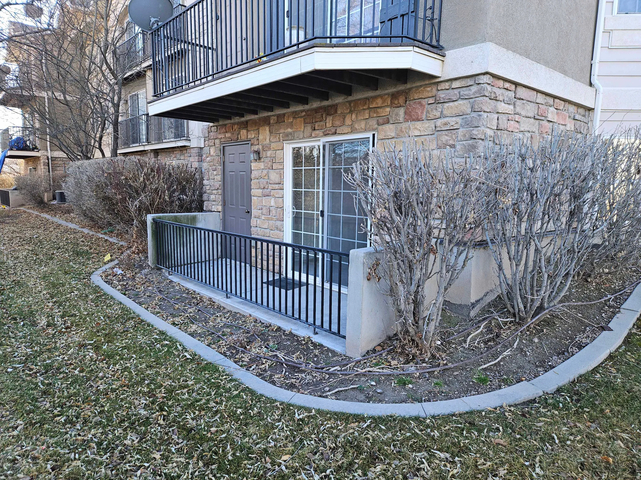 View of side of home featuring a balcony and stone siding