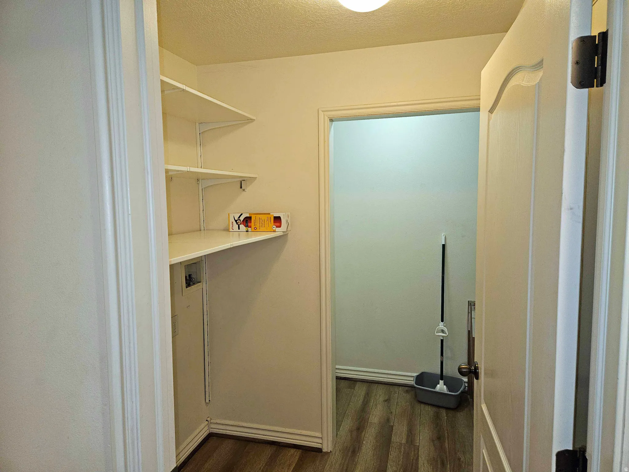 Washroom featuring dark wood-type flooring, washer hookup, and a textured ceiling