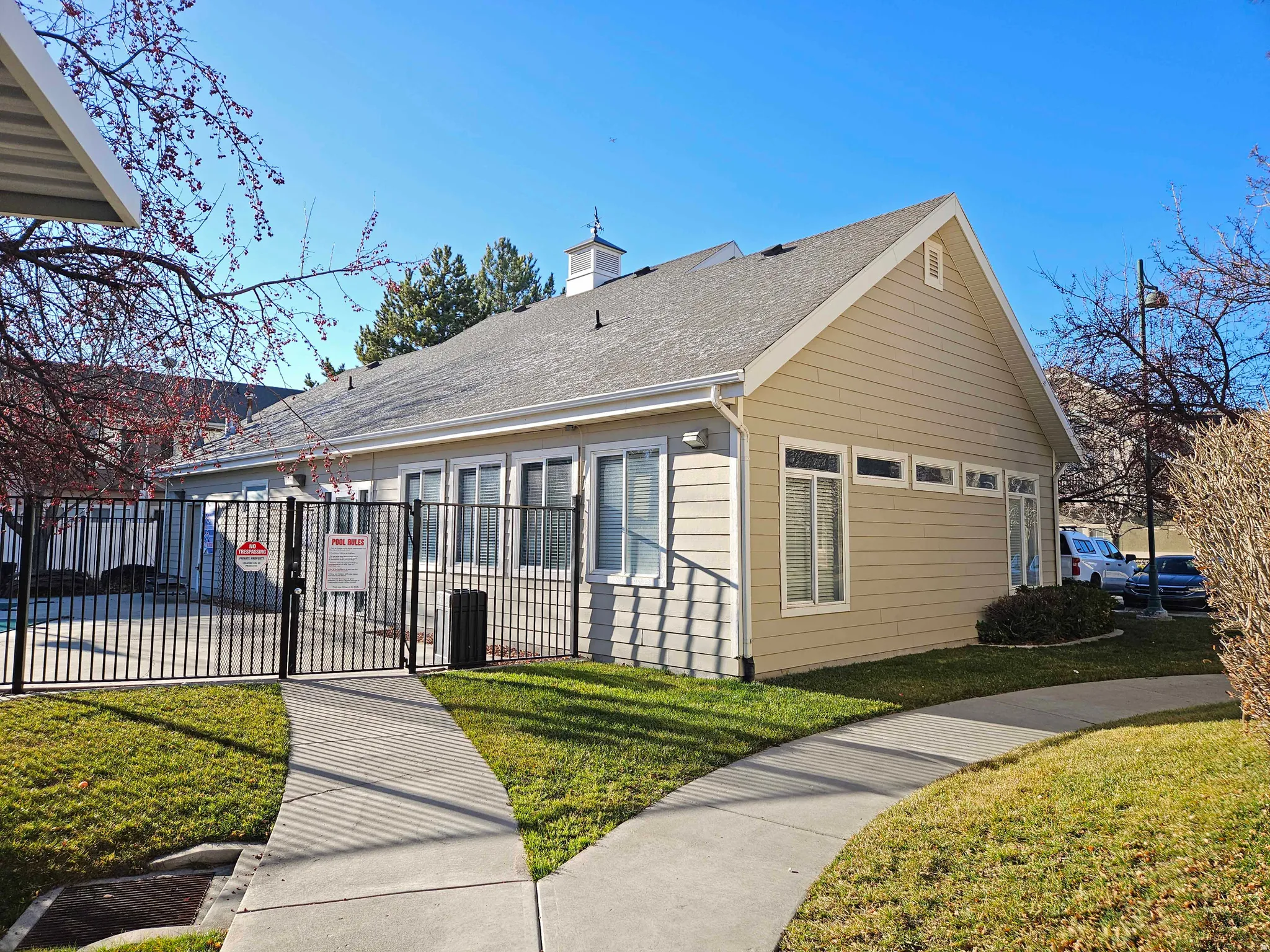 View of property exterior featuring a gate, roof with shingles, and a chimney