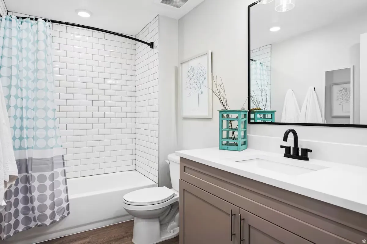 Full bath with vanity, shower / bath combination with curtain, recessed lighting, and dark wood-type flooring