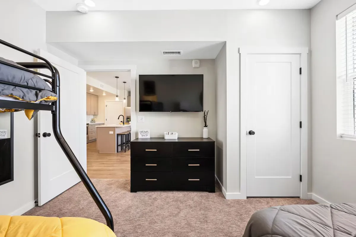 Bedroom featuring light colored carpet and baseboards