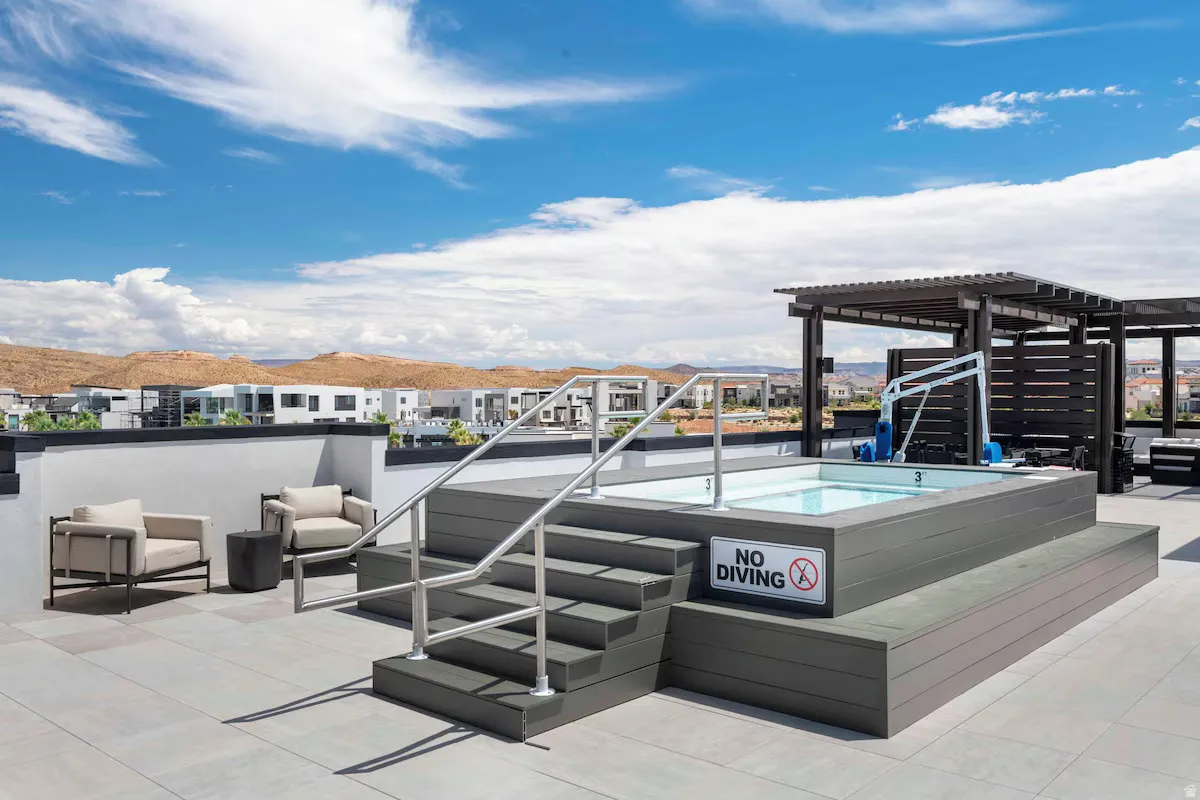 View of patio / terrace with a hot tub and a pergola