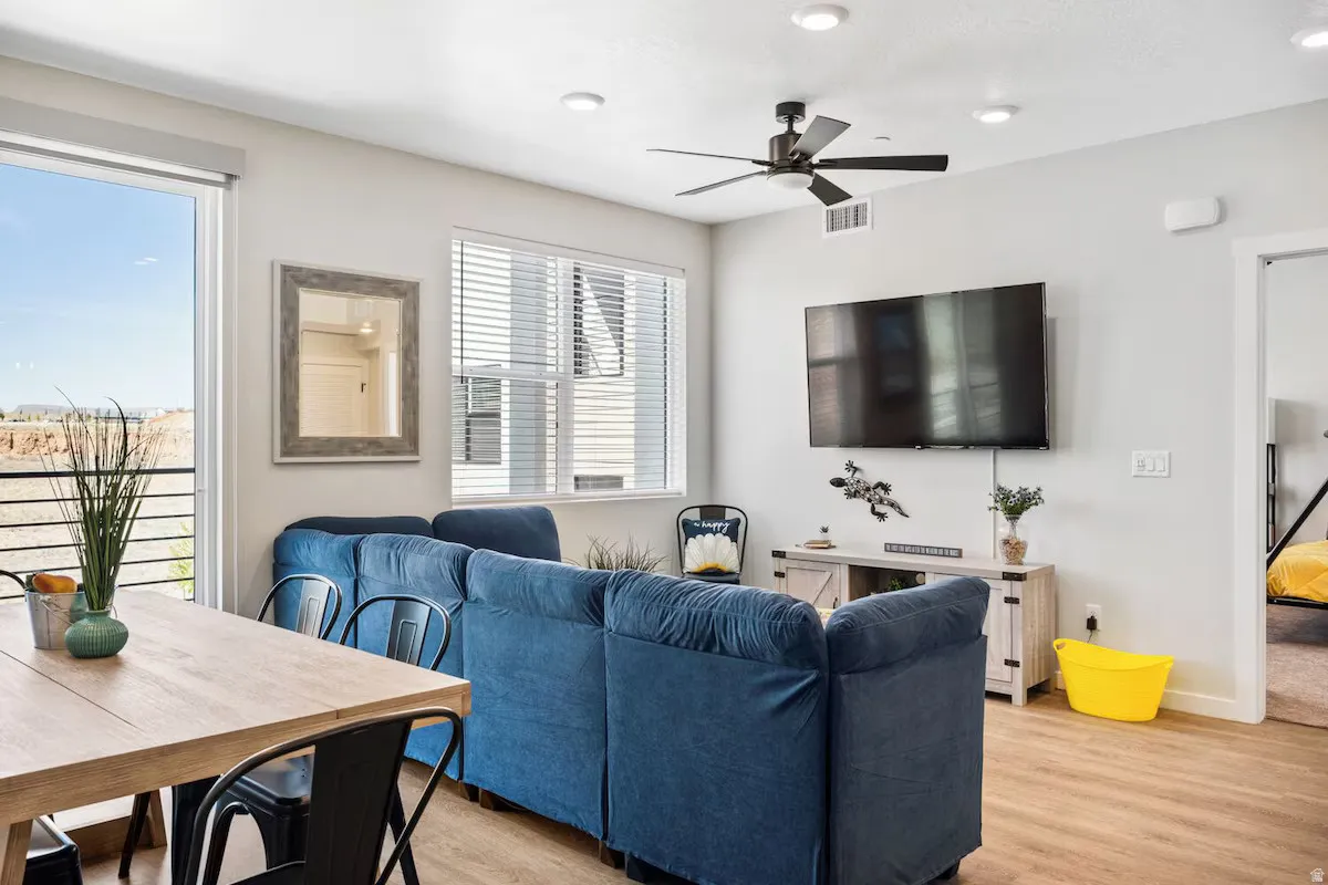 Living area featuring light wood-type flooring, a ceiling fan, and recessed lighting