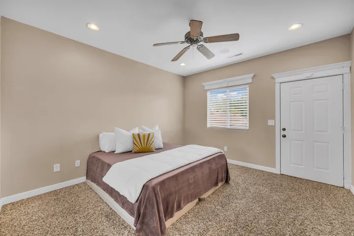 Carpeted bedroom featuring a ceiling fan and recessed lighting