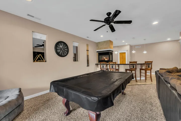Recreation room featuring billiards, ceiling fan, a glass covered fireplace, carpet flooring, and recessed lighting
