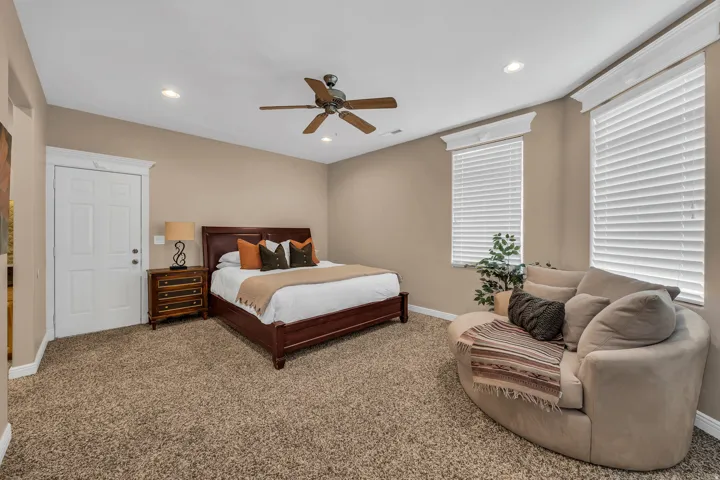 Carpeted bedroom featuring a ceiling fan and recessed lighting
