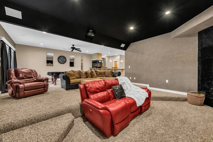 Carpeted cinema room with recessed lighting, ceiling fan, and lofted ceiling