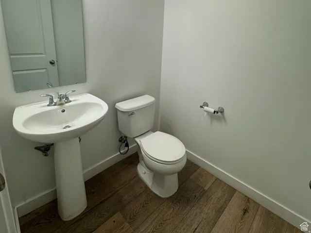 Bathroom featuring baseboards and dark wood-type flooring