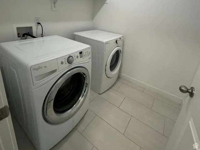 Washroom featuring washer and dryer and tile patterned flooring