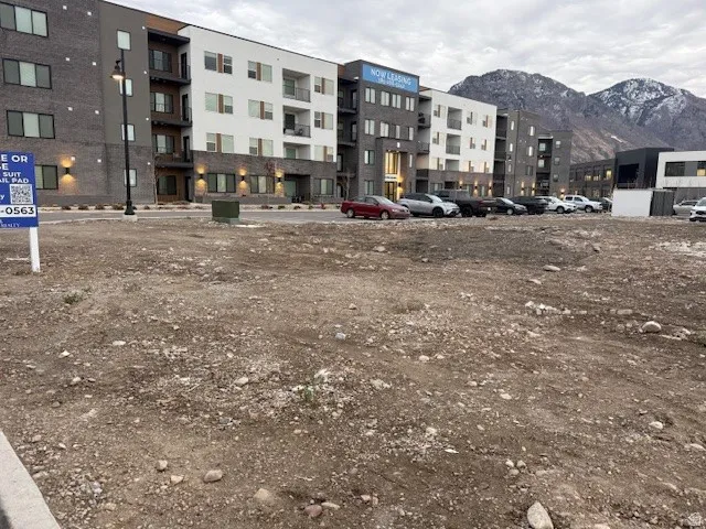 View of apartment building / complex with uncovered parking and a mountain view