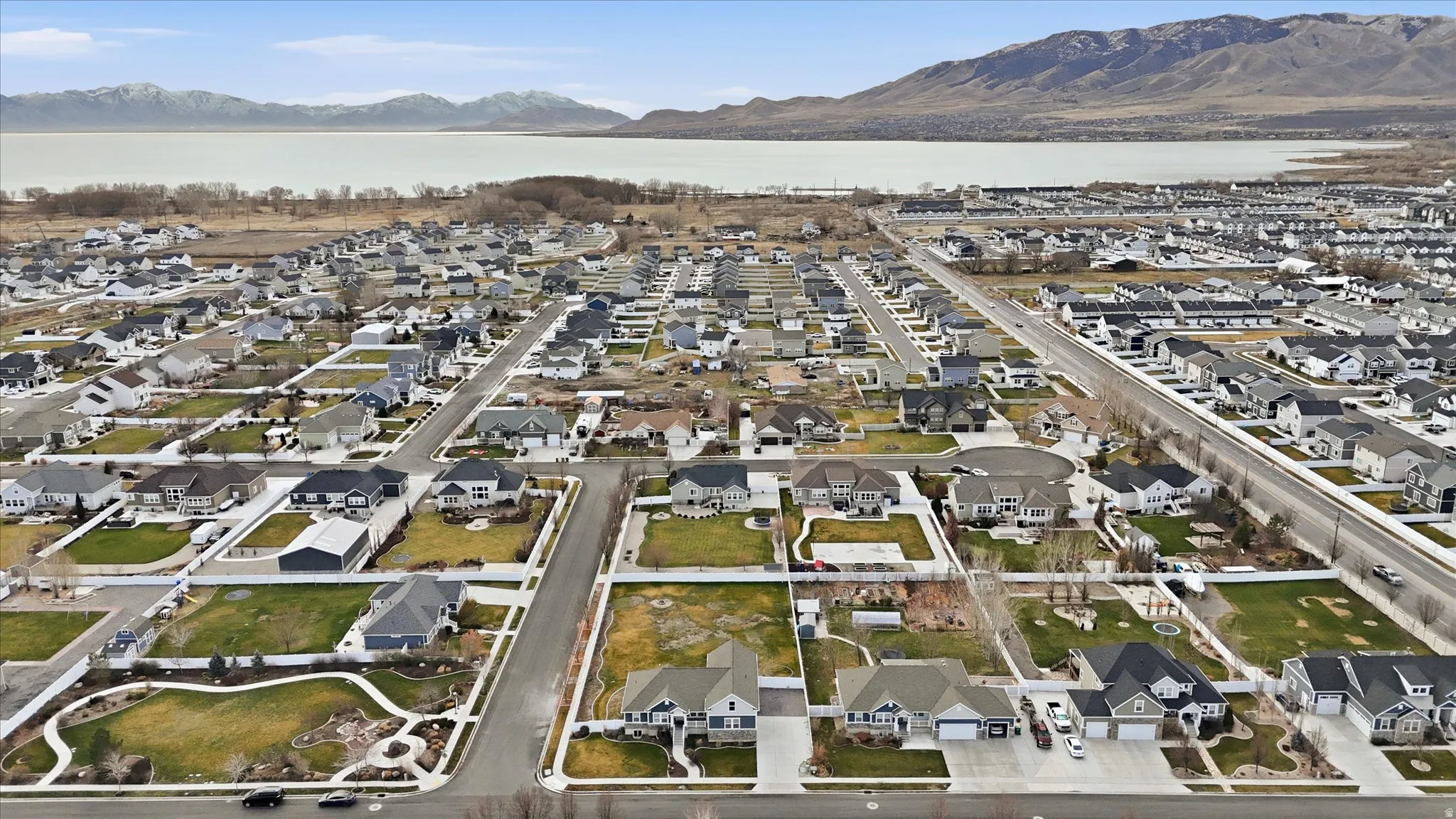 Aerial view of property's location with nearby suburban area and a mountain backdrop and Utah Lake