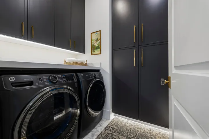 Laundry area with cabinet space, washer and dryer, and light marble finish floors