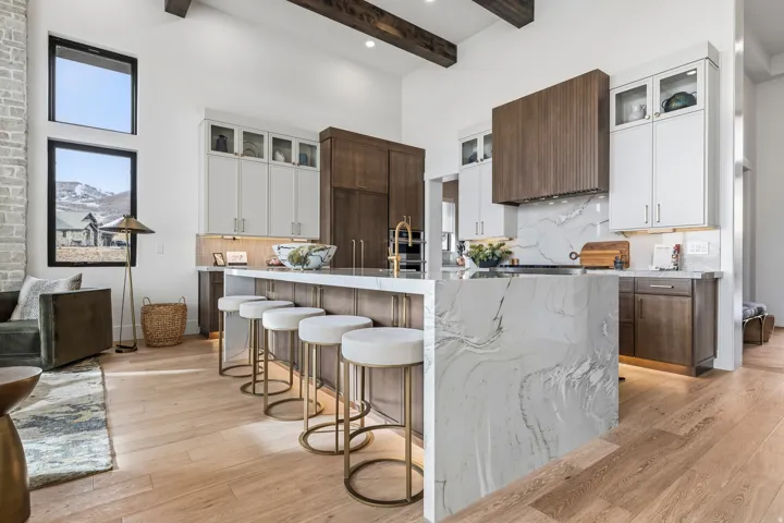 Kitchen with decorative backsplash, glass insert cabinets, white cabinetry, a high ceiling, and beam ceiling