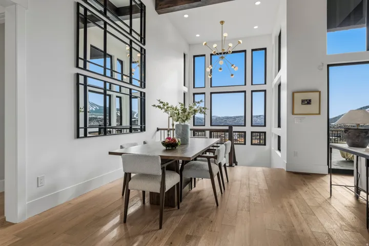Dining space with a chandelier, light wood-type flooring, plenty of natural light, recessed lighting, and a towering ceiling