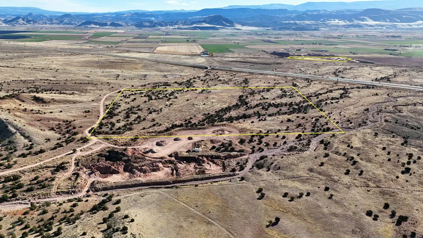 Expansive undeveloped land featuring diverse terrain, mature brush, and distant mountain ranges