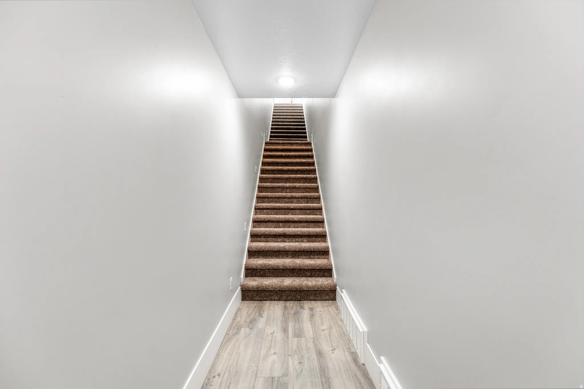 Stairs featuring wood finished floors and baseboards