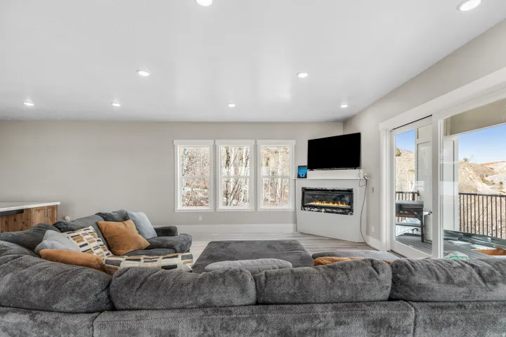 Living room featuring a glass covered fireplace, recessed lighting, and wood finished floors