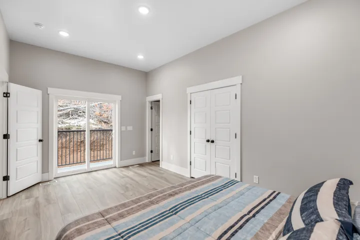 Bedroom featuring wood finished floors, access to outside, a closet, and recessed lighting