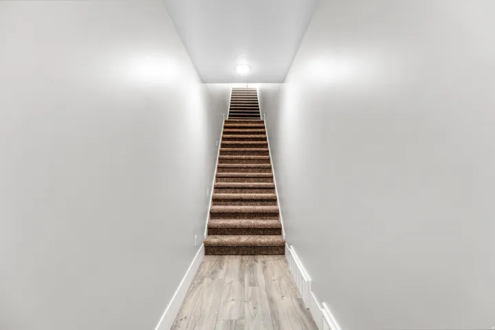Stairs featuring wood finished floors and baseboards