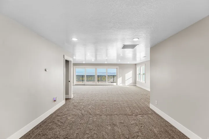 Carpeted spare room featuring a textured ceiling and recessed lighting