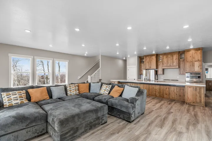 Living room featuring light wood-style flooring, stairs, and recessed lighting
