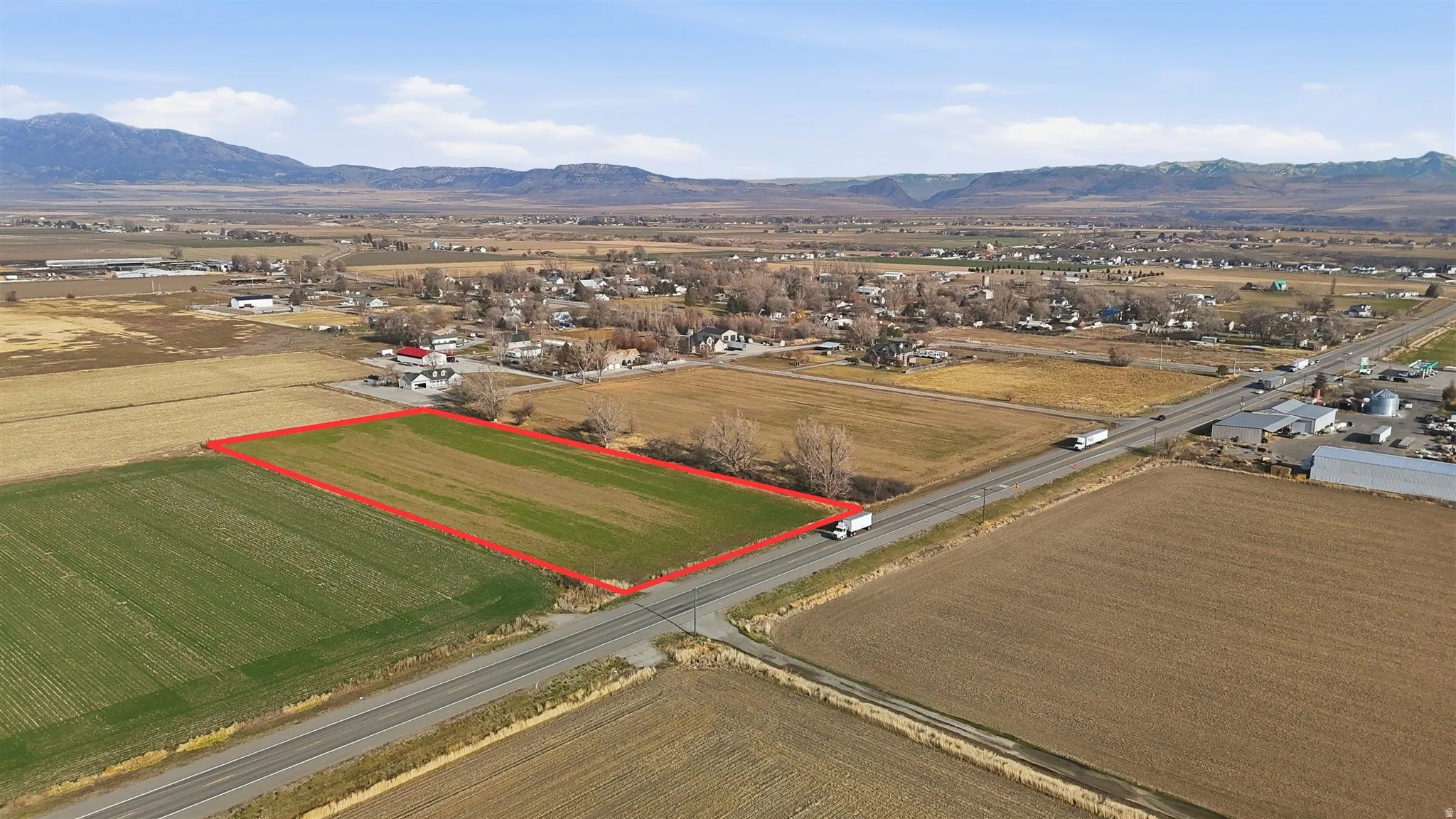 Aerial view of sparsely populated area with property boundaries highlighted, mountains, and abundant farmland