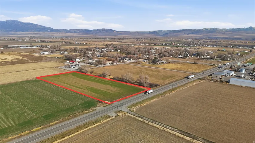 Aerial view of sparsely populated area with property boundaries highlighted, mountains, and abundant farmland