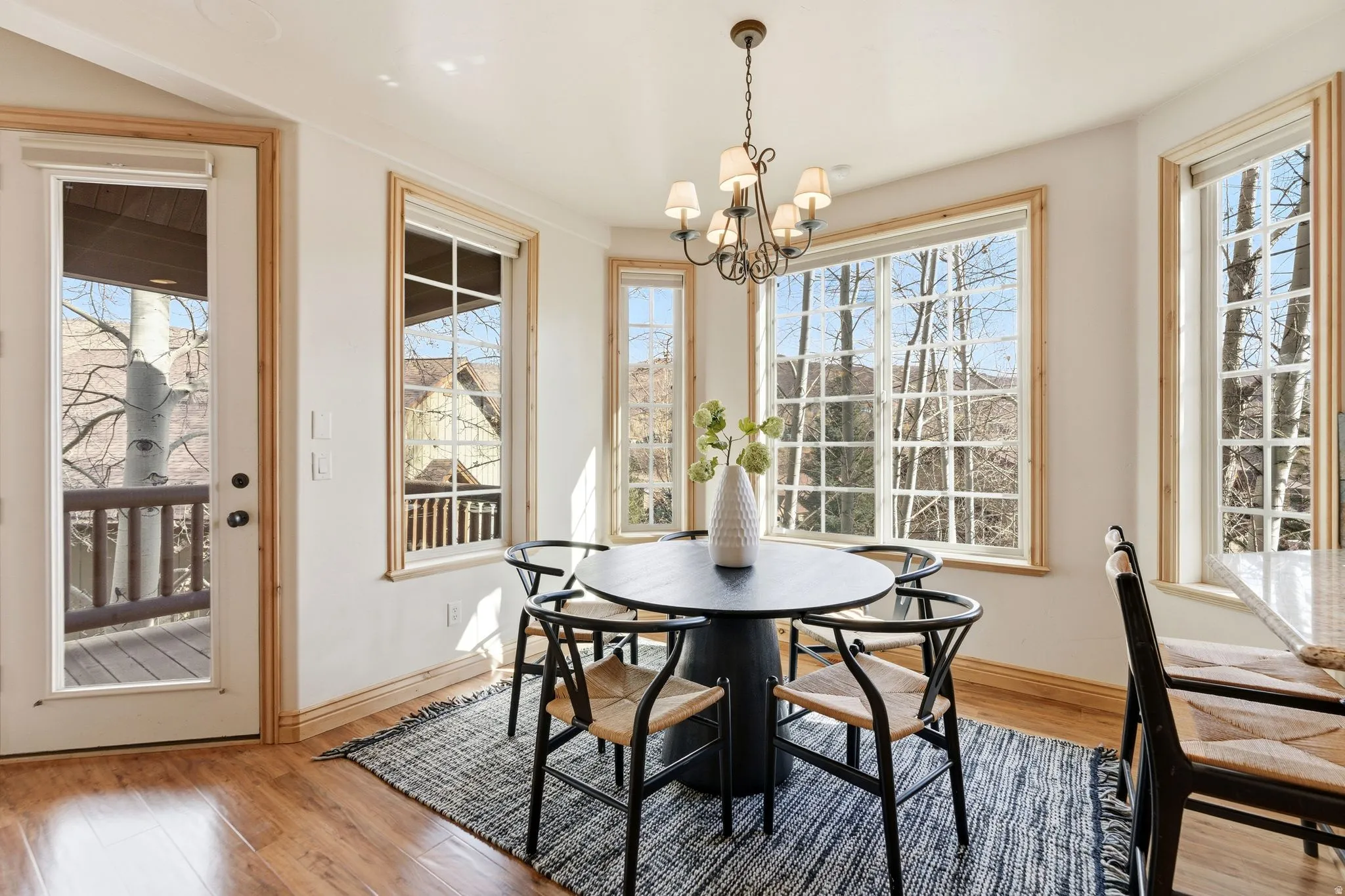 Dining room featuring light wood-style flooring, healthy amount of natural light, and a chandelier