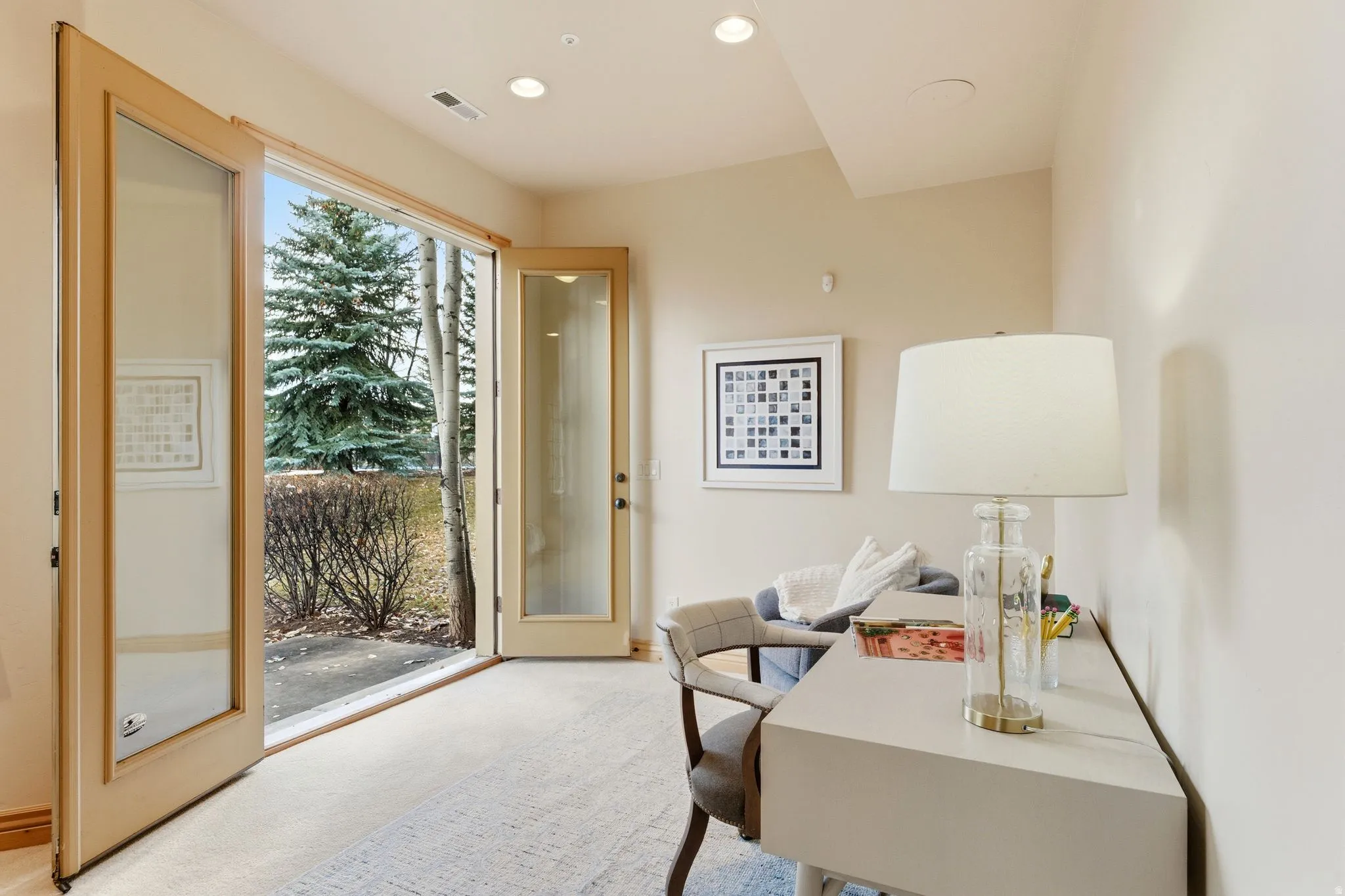 Office space with light carpet and recessed lighting