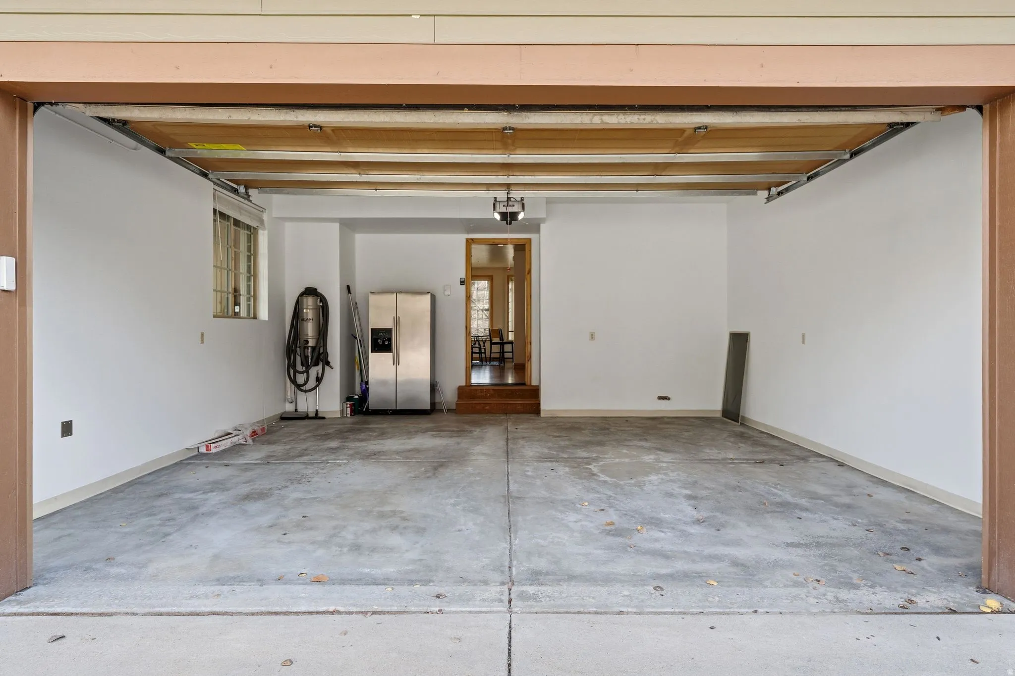 Garage with stainless steel fridge with ice dispenser and a central vacuum unit