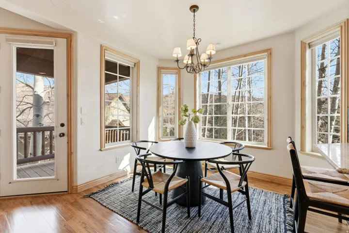 Dining room featuring light wood-style flooring, healthy amount of natural light, and a chandelier