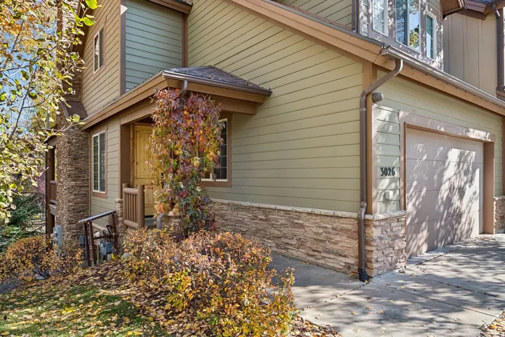 View of property exterior featuring an attached garage and stone siding