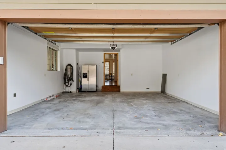 Garage with stainless steel fridge with ice dispenser and a central vacuum unit