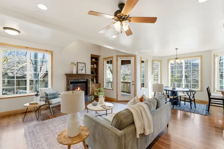 Living room featuring a tiled fireplace, healthy amount of natural light, ceiling fan, hardwood / wood-style floors, and recessed lighting