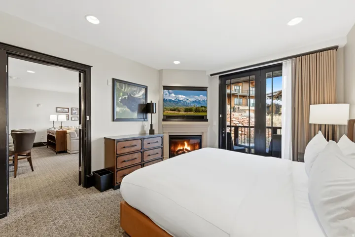 Bedroom with carpet, access to outside, and a glass covered fireplace