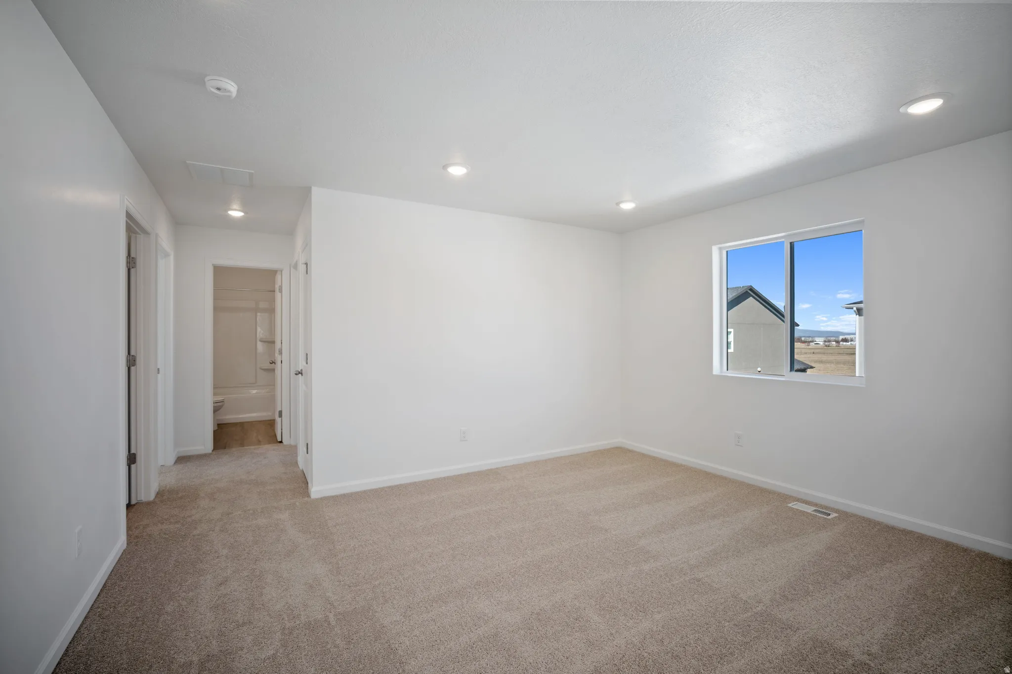 Spare room with light colored carpet and recessed lighting