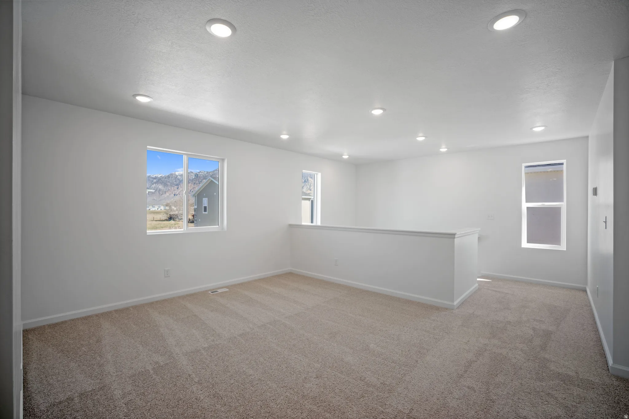 Spare room featuring light colored carpet and recessed lighting